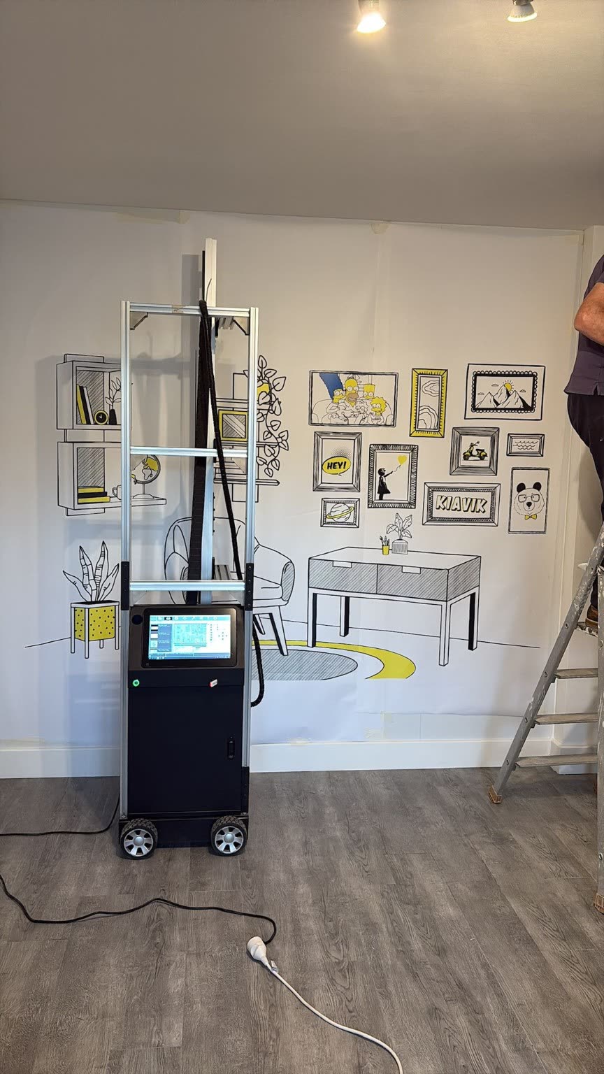 Imprimante murale verticale devant un décor intérieur imprimé sur un mur blanc